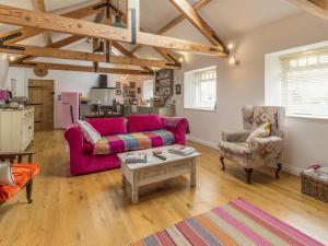 a living room with a couch and a table at The Cowshed in Horsley