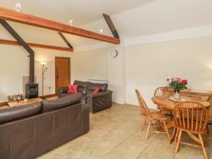 Keepers Cottage في بلاندفورد فوروم: غرفة معيشة مع أريكة وطاولة