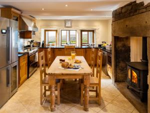 a kitchen with a wooden table and a stove at The Retreat in Hebden Bridge