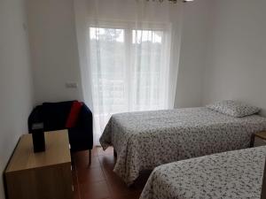 En eller flere senger på et rom på Cozy apartment in Algarve West Coast - Aljezur (2 min da Praia Monte Clérigo)