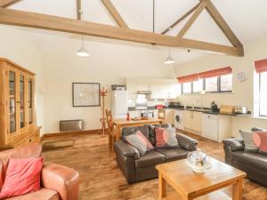 a living room with two couches and a kitchen at The Old Cart Shed in Blandford Forum