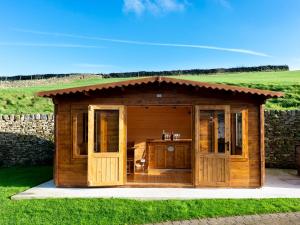 a small wooden building in the middle of a field at The Retreat in Hebden Bridge