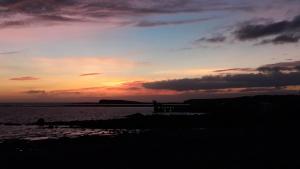 a sunset over the ocean with the sun setting at The Thatched Cottage B&B in Claregalway
