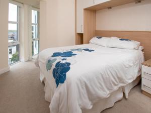 a bedroom with a white bed with blue flowers on it at The Moorings in Conwy