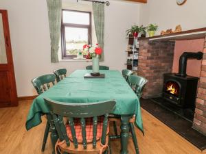 a dining room with a table and a fireplace at The Old Farmhouse in Llanrwst