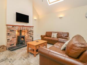 a living room with a couch and a fireplace at Pear Tree Cottage in York