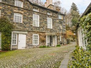 an old stone house on a cobblestone street at The Old Laundry in Ambleside