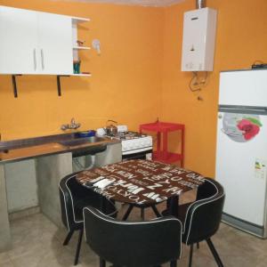 a kitchen with a stove and a table with chairs at Casas Cordoba in Villa Parque Siquiman