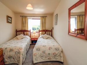 大托靈頓的住宿－Primrose Cottage，一间卧室配有两张床和镜子