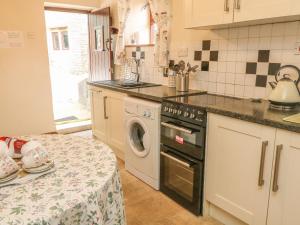 a kitchen with a washing machine and a table at Stable Barn in Ashbourne