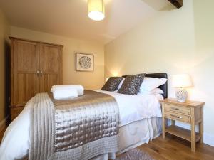 a bedroom with two beds and a night stand at Grove Cottage in Copley