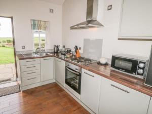 a kitchen with white cabinets and a microwave at Beacon in Saltburn-by-the-Sea +9 photos
