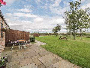 a patio with a table and a picnic table in the grass at Beacon in Saltburn-by-the-Sea