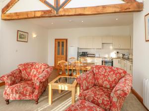 a living room with two chairs and a table at Swift Cottage in Brampton