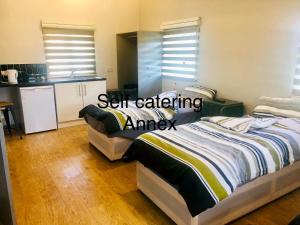 1 dormitorio con 2 camas y cocina en Elmcroft Guest House, en Epping