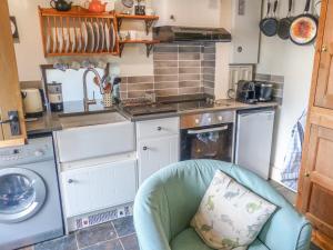 cocina con silla y lavadora en The Old Stable en Abergavenny
