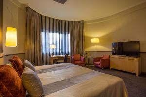 a hotel room with two beds and a television at Mamaison Hotel Andrassy Budapest in Budapest