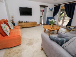 a living room with two couches and a tv at The Coach House in Bristol