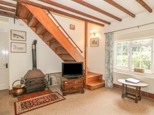 a living room with a wood stove and a tv at The Old Smithy in Bridport