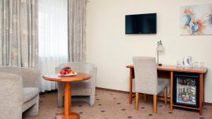 a room with a table and two chairs and a desk at Hestia Hotel Draugi in Riga
