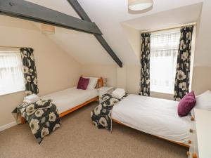 duas camas num quarto com duas janelas em Kingfisher em Whitland
