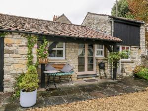 a cottage with a patio with a table and chairs at The Coach House in Bristol