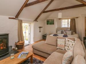 a living room with a couch and a fireplace at Hawthorn Cottage in Llandysul