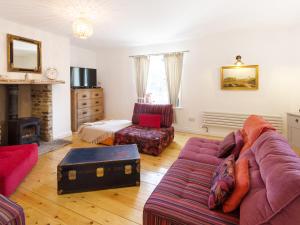 a living room with a couch and a chair at The Dale Townhouse in Allendale Town