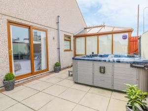 a hot tub on the patio of a house at Smithy Cottage in Cemaes Bay