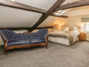 a bedroom with a king sized bed and a blue couch at The Farmhouse in Whitby