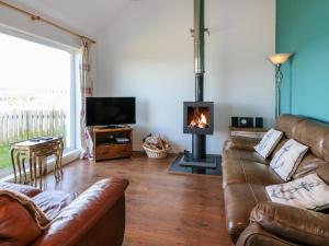 a living room with a couch and a fireplace at Starfish Cottage in Craignure
