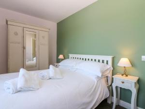 a bedroom with a white bed with two white pillows at Driftwood Cottage in Craignure