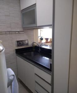 una pequeña cocina con fregadero y microondas en Rio Vista Mar, en Río de Janeiro