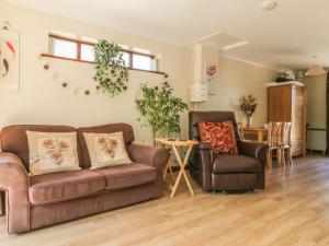 a living room with two couches and a table at Kingfisher in Wattisfield