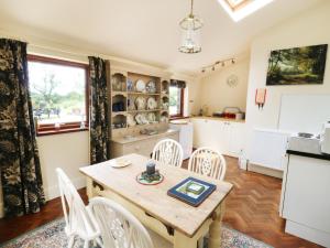 a kitchen and dining room with a table and chairs at Woodlands in Halton West