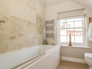 ein Bad mit einer Badewanne und einem Fenster in der Unterkunft Mulberry Cottage in Hadleigh + 10 Fotos