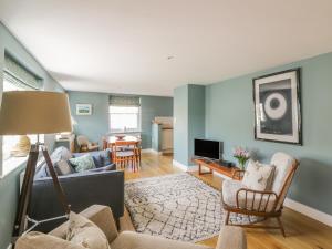 a living room with a couch and a tv at Mulberry Cottage in Hadleigh