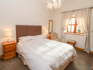 una camera da letto con un letto grande e un lampadario di Dove Cottage a Brampton