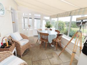 a dining room with a table and chairs and windows at Croft View in Whitby