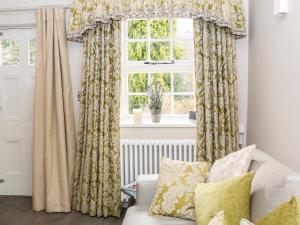 a living room with a white couch and a window at Ash Cottage in Bakewell