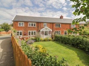 a brick house with a garden in front of it at Mulberry Cottage in Hadleigh