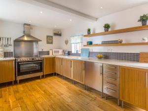 a large kitchen with wooden cabinets and a stove at Estuary View in Warkworth