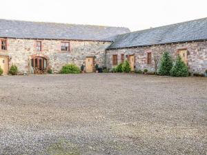 una vecchia casa in pietra con un grande vialetto di Dove Cottage a Brampton