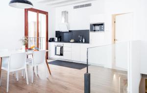 a kitchen with white cabinets and a table and chairs at Apartamento Santa Creu in Palma de Mallorca