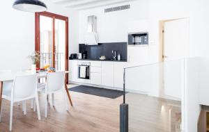 a kitchen with white cabinets and a table and chairs at Apartment Santa Cruz Suite TI105 in Palma de Mallorca