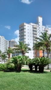 um parque com palmeiras em frente aos edifícios em Apartamento na Praia na Praia Grande