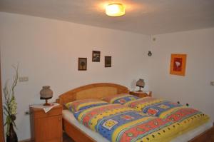 een slaapkamer met een groot bed en kleurrijke dekens bij Bauernhof Mittereibenberger in Liebenau