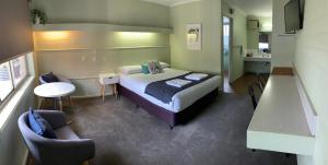 a bedroom with a bed and a table and a chair at Finley Country Club Hotel Motel in Finley