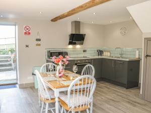 a kitchen and dining room with a table and chairs at The Hay Loft in Craven Arms