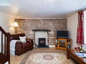 a living room with a couch and a fireplace at 3 Horse Pool Road in Laugharne